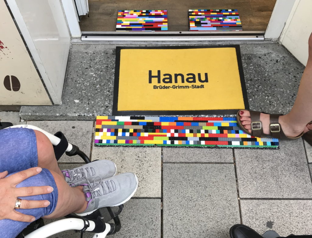 1. Rampe: Hanau Laden am Freiheitsplatz. Das Bild zeigt die beidseitige LEGO-Rampe mit einem gelben Fußabtreter in der Mitte. Dieser trägt in schwarzen Buchstaben die Aufschrift Hanau.