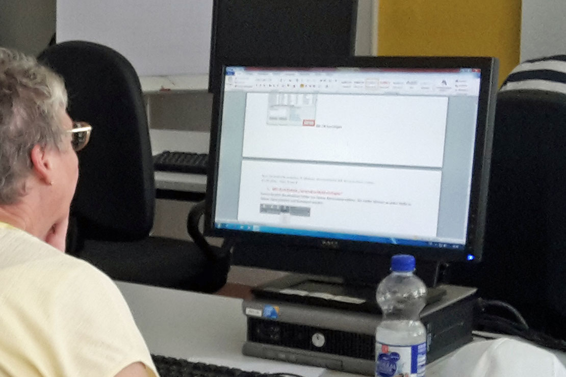 Das Bild zeigt eine Frau, im Computerraum, die das Gelernte umsetzt