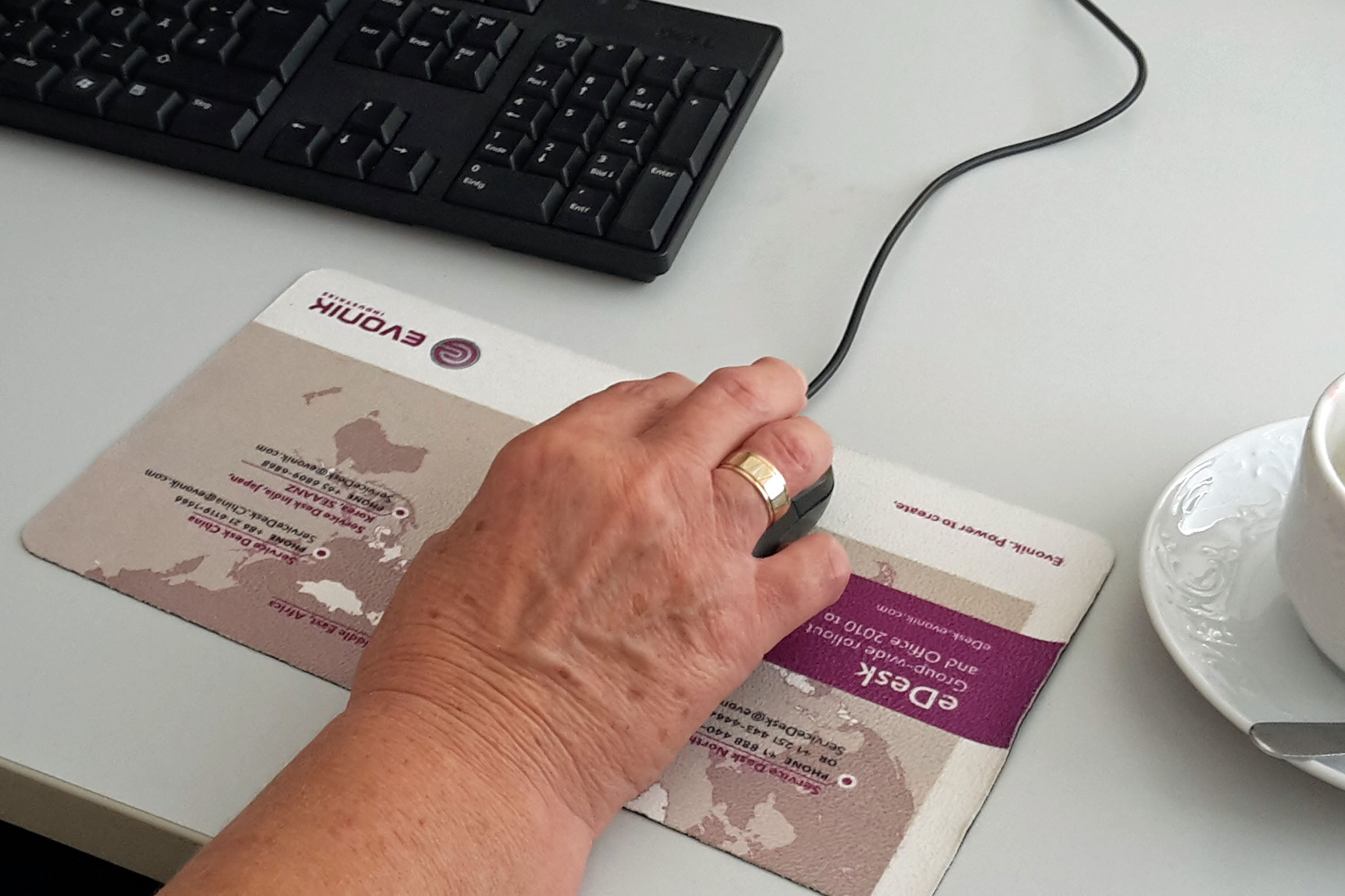 Das Bild zeigt die Hand einer Frau, die eine PC-Maus bewegt