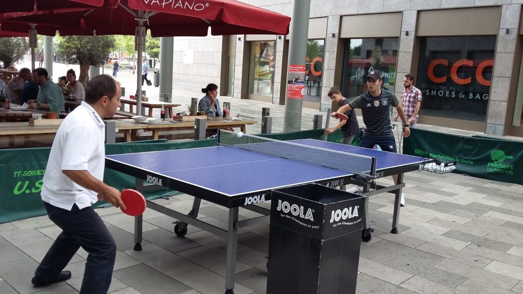Ein junger Mann und ein älterer Herr spielen Tischtennis