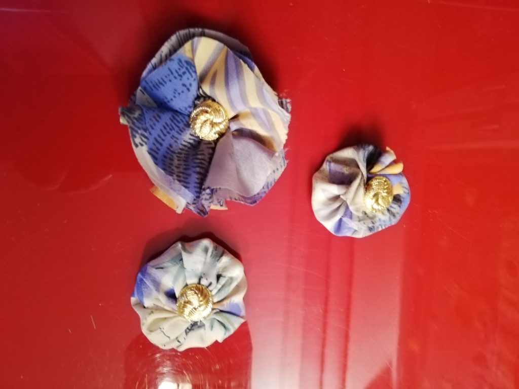 Geschenkschmuck aus alter Kleidung: hier zu sehen drei Anklebeblumen.