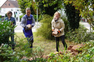 2022: Zwei Frauen und ein Mann tragen Steine für das Sandarium im Lindenaupark.