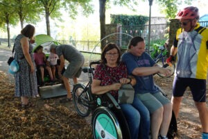 Zwei Rikscha parken hintereinander und sind voll geladen mit Fahrgästen.