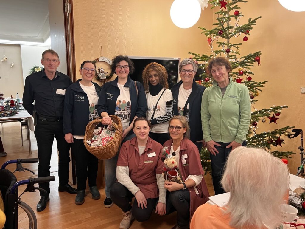 Gruppenbild von Menschen in Hanau engagierten und Mitarbeiterinnen des Heims vor einem Weihnachtsbaum