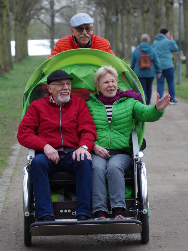 Eine Pärchen wir winkend mit der Rikscha ausgefahren