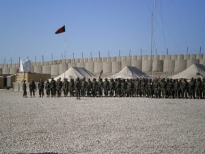 Das Bild zeigt die afghanische Armee auf einem Militärplatz. Im Hintergrund ist die afghanische Flagge zu sehen.