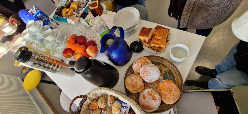 Ein Frühstückstisch mit Brötchen, Kaffeekannen und Tellern