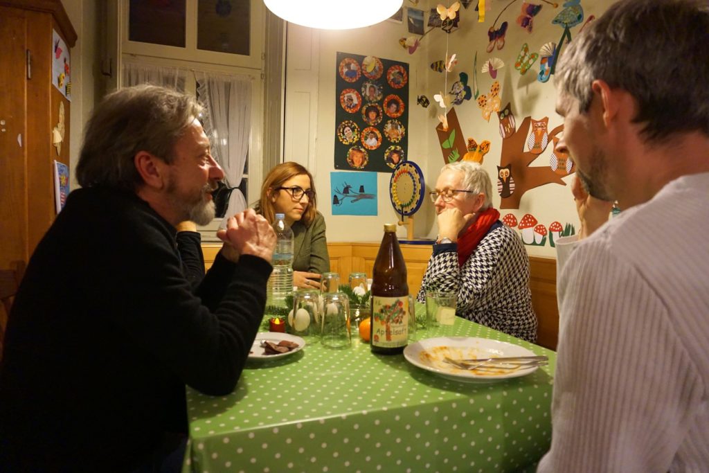 Das Bild zeigt Norbert, Anna, Renate und im Profil Daniel. Der Nachtisch ist noch auf dem Tisch erkennbar.