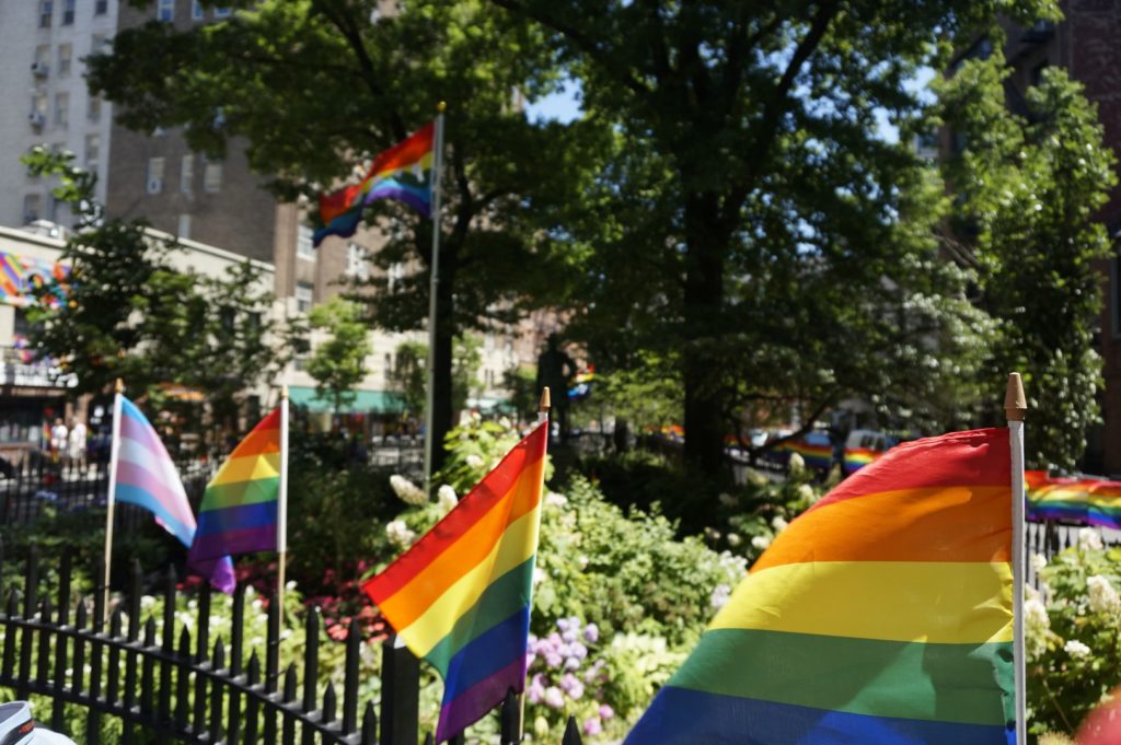 Das Stonewall Memorial an der Christopher Street. Viele Regenbogen-Fahnen sind an den Zäunen befestigt.