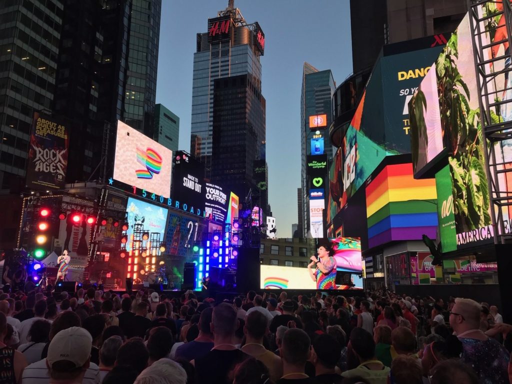 Feierlaune auf dem Times Square. Einige Tausend Menschen haben sich auf dem Times Square versammelt. Die bunten Lichterwände erstrahlen oft in Regenbogen-Farben.