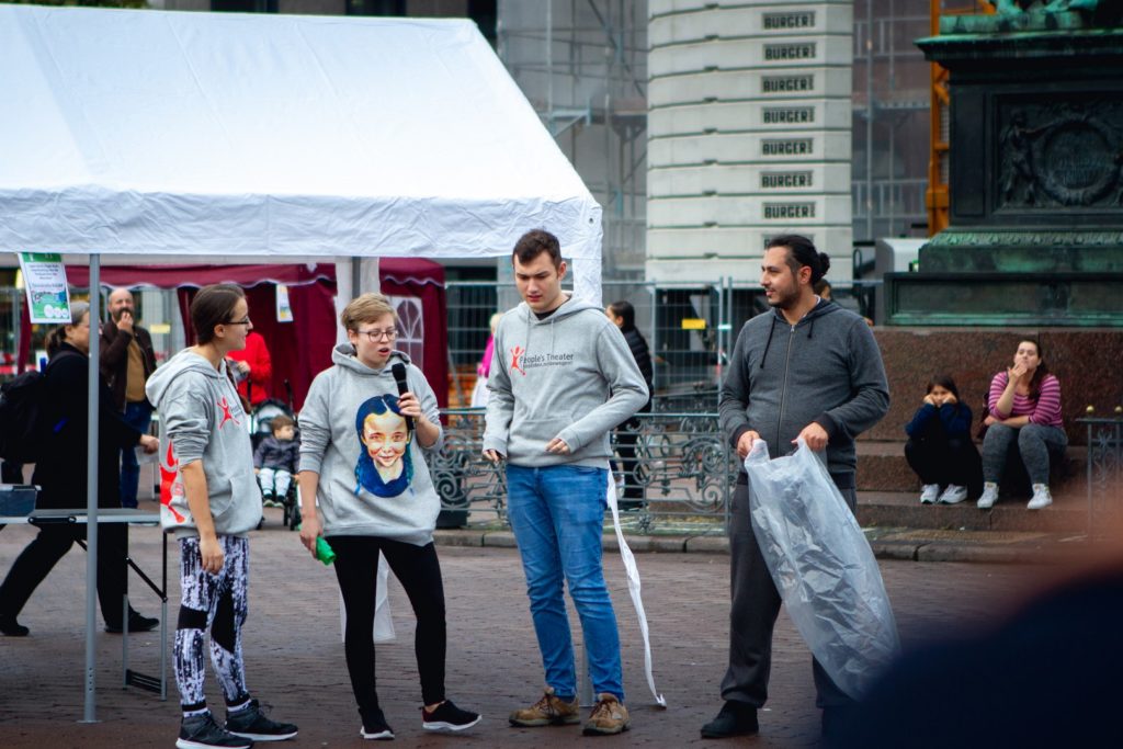 Jugendtheatergruppe zeigt Plogging auf dem Marktplatz - eine Kombination von Plastiksammeln beim Jogging.