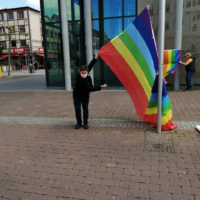 Zwei Personen hängen eine große Regenbogenfahne in Hanau auf als Demonstration für den Internationaler Gedenktag gegen Homo- und Transphobie (IDAHOBIT) am 17. Mai.