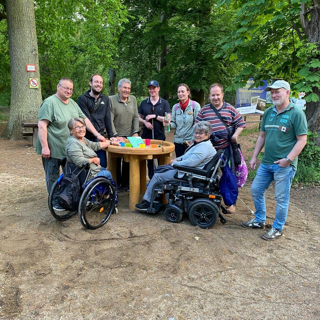 Das Checker-Team steht zu einem Gruppenfoto um einen runden Tisch im Wildpark Fasanerie