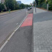 Ein rot gekennzeichnet Stück Radweg markiert eine Ein- bzw- Ausfahrt als Gefahrequelle