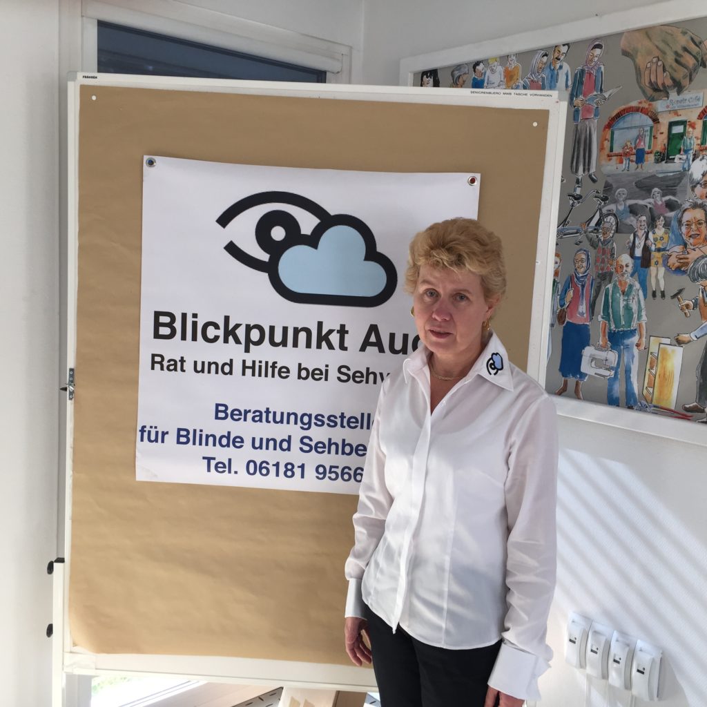 Ihr Ansprechpartner vor Ort: Frau Silvia Schäfer (auf dem Bild zu sehen vor einem Plakat 'Blickpunkt Auge')