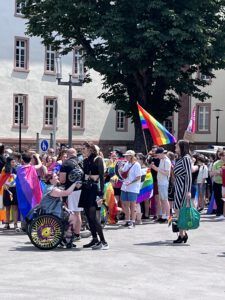 Viele menschen mit bunten Regenbogen-Fahnen und Klamotten stehen auf dem Freiheitsplatz.