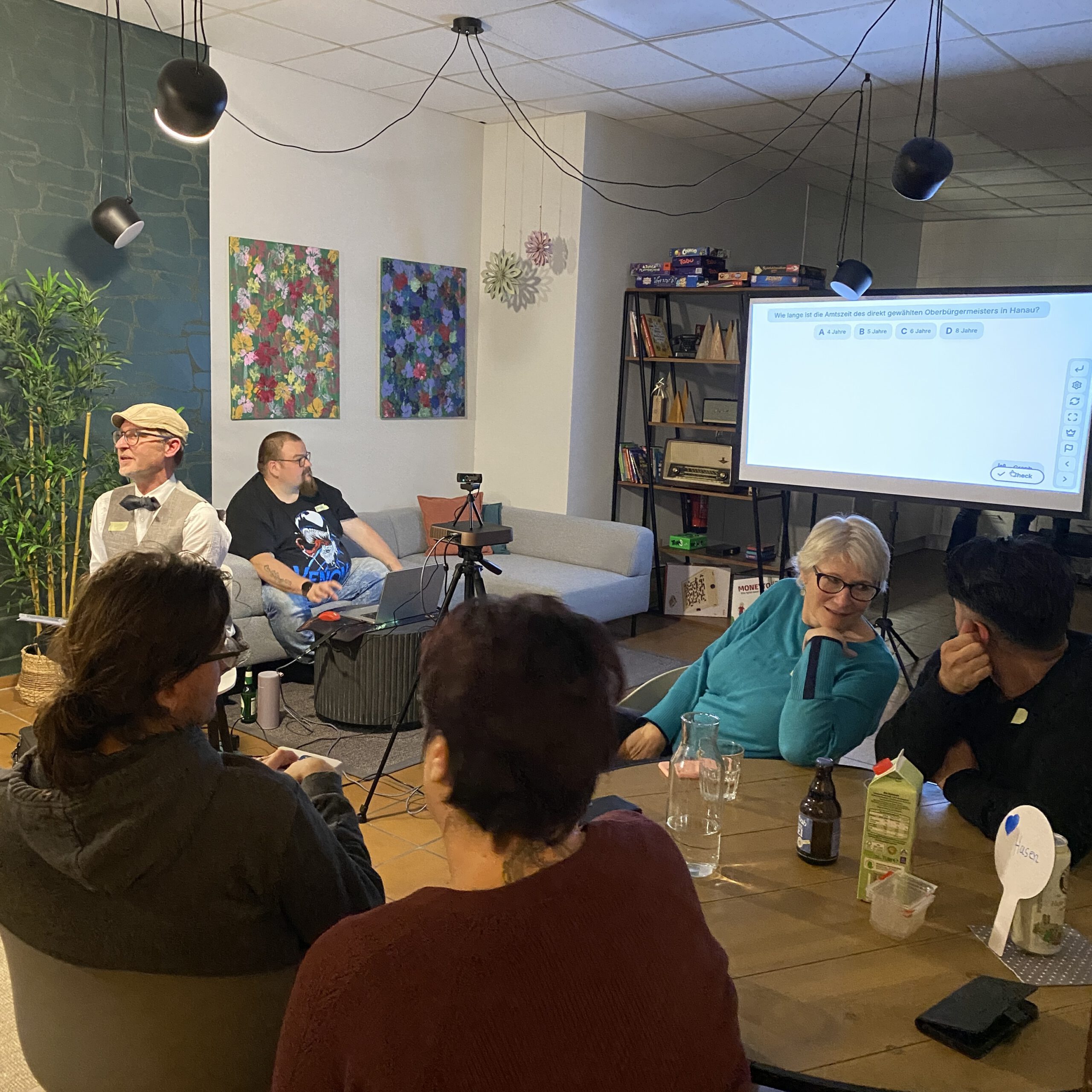 Gruppe sitzt im Raum und überlegt über eine QUizfrage