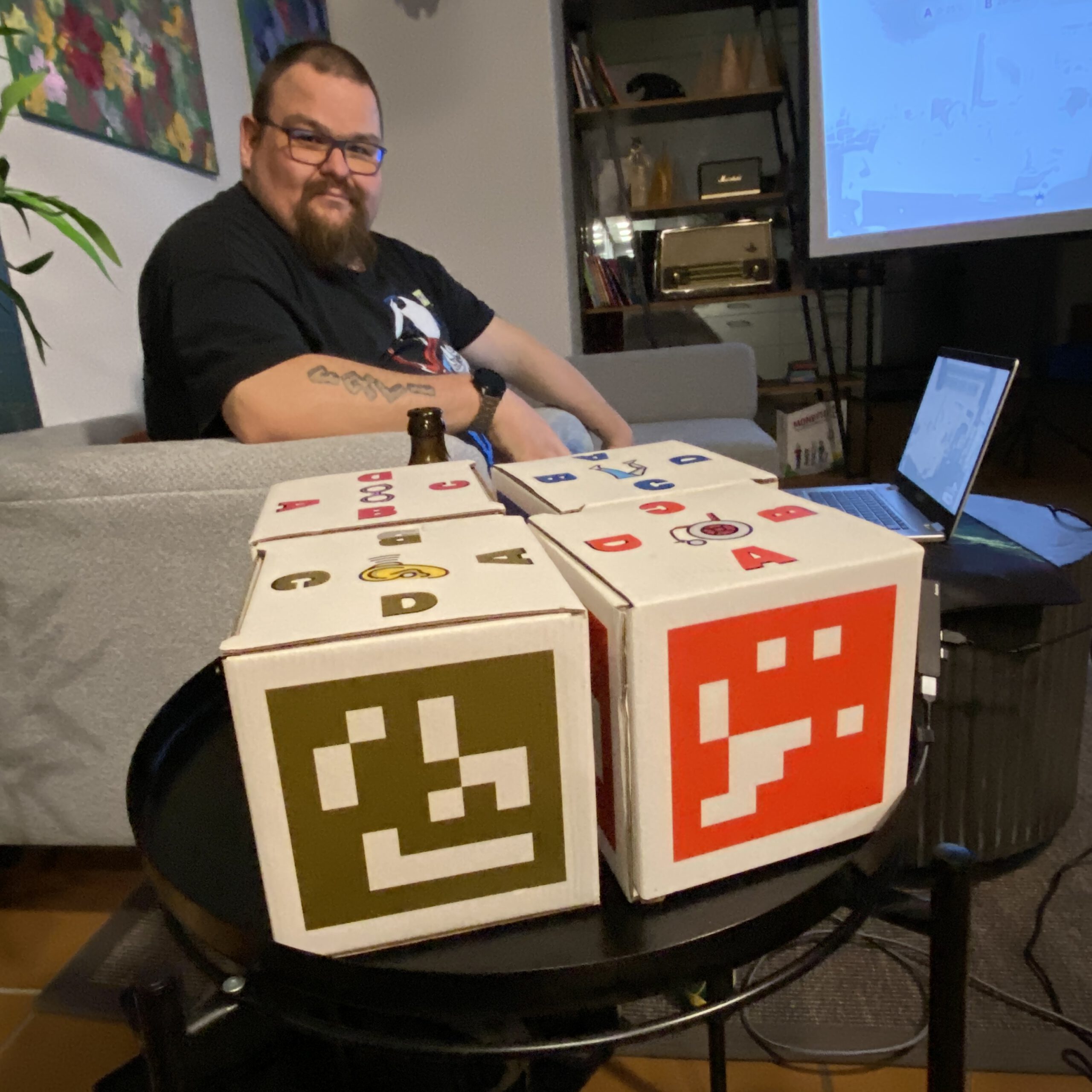 Stefan sitzt an der Technik und vor der Quizwürfeln.