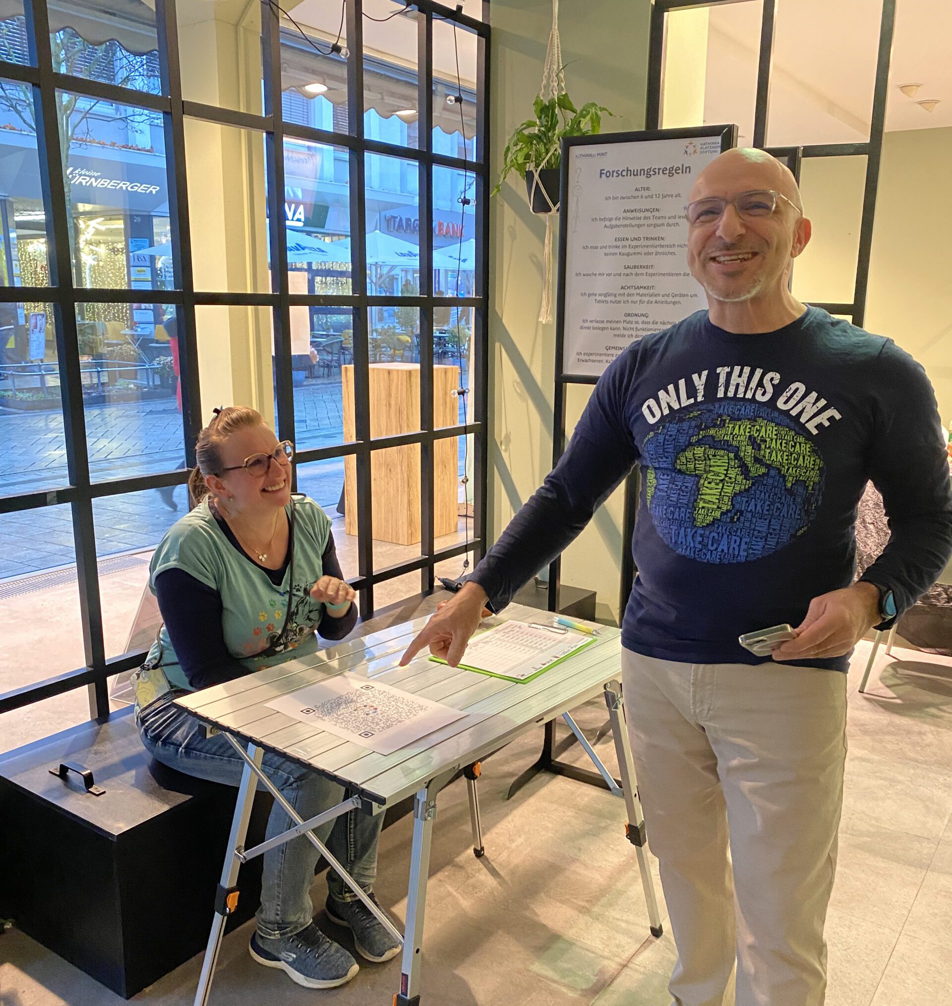 Paulo zeigt auf den QR-Code zum beantworten.