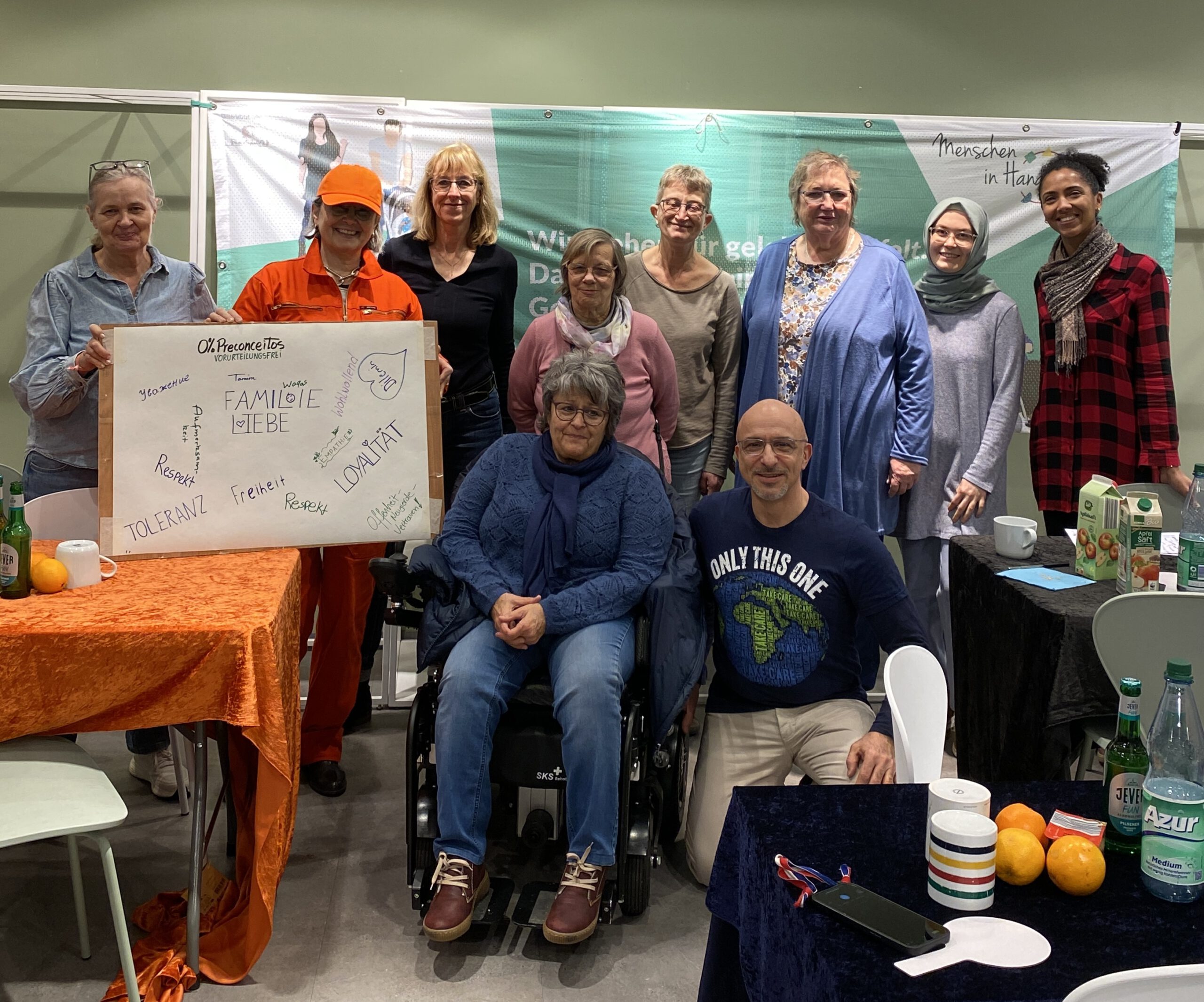 Gruppe steht für eine Foto mit der Künstlerin und einem Plakat zusammen.