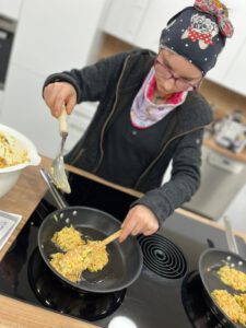 Eine Frau die etwas in einer Pfanne brät