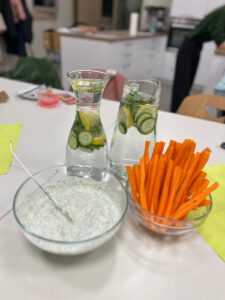 Auf dem Tisch stehen Gemüse, Quark und Wasser mit Gurke und Zitrone