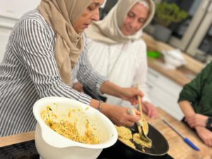 2 Frauen mit Kopftüchern braten etwas