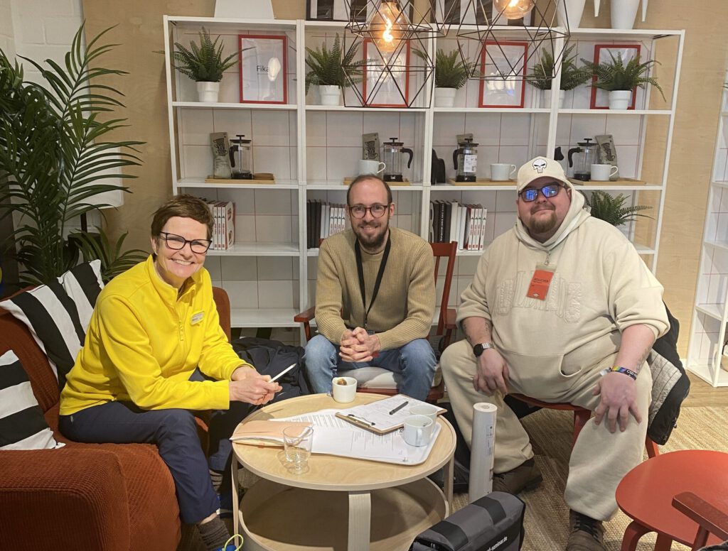 Stefanie, Julian und Stefan sitzen auf Ikea-Stühlen für ein Gruppenbild