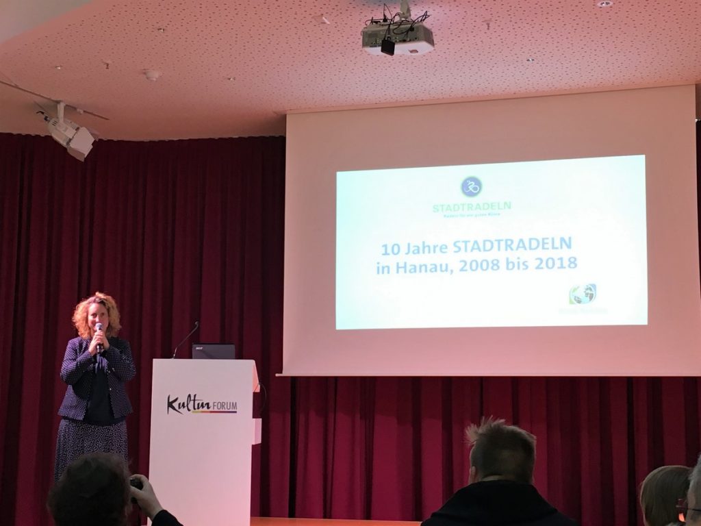 Anja Zeller eröffnet die Veranstaltung. Hinter ihr eine Folie zu 10 Jahre Stadtradeln in Hanau.