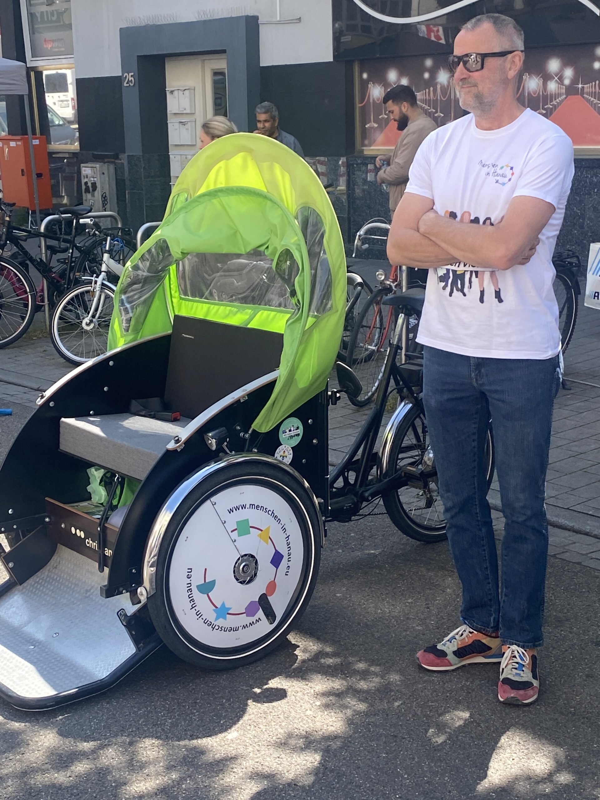 Martin mit Sonnenbrille steht neben einer grünen Rikscha