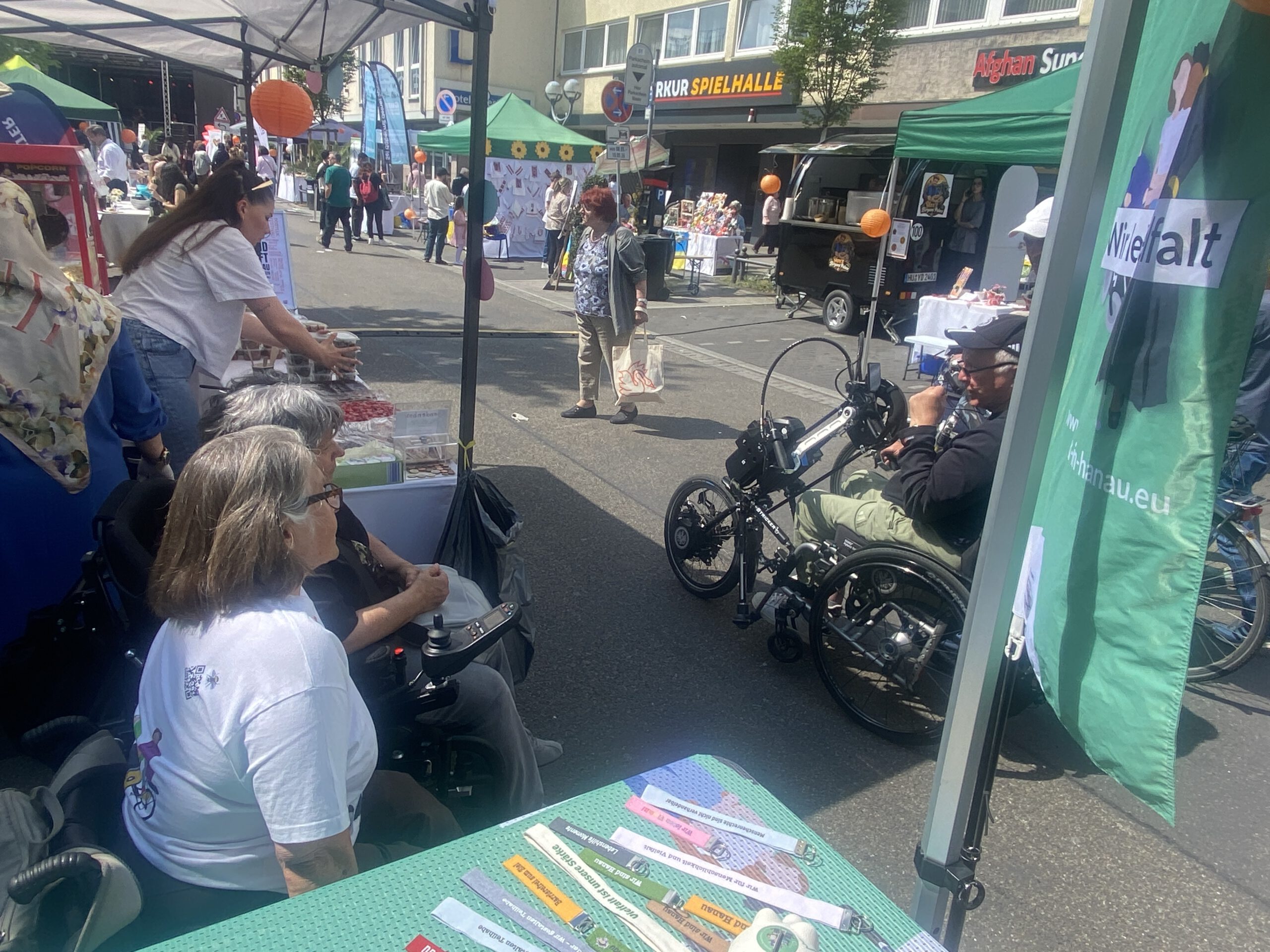 Gaby und Marianne sprechen mit einem vorbeifahrenden Rollstuhlfahrer