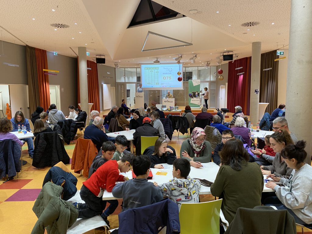 Ganz viele Menschen sitzen um Tische im Kulturforum und spielen Bingo