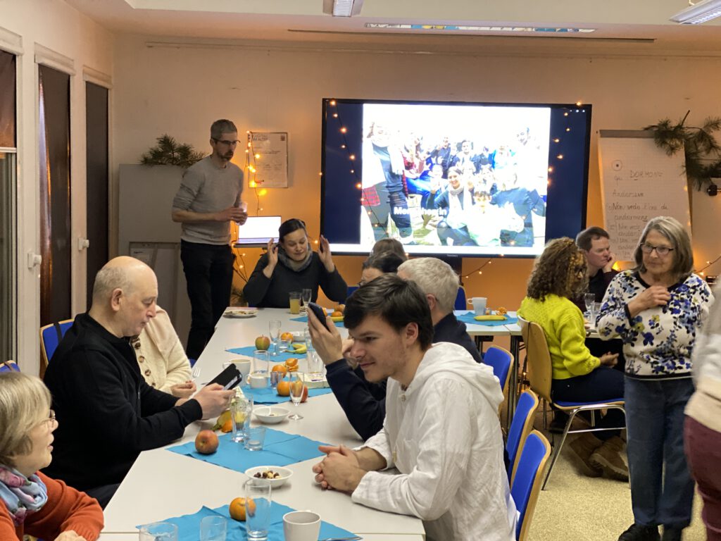 Viele Menschen sitzen um einen Tisch der geschnmückt ist