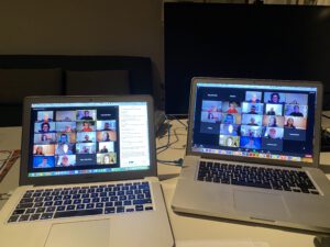 2021: Zwei Laptops auf denen Zoom-Konferenzen zu sehen sind mit vielen Beteiligten.