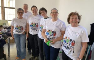 2025: MiH-Team auf der Nachhaltigkeitsmesse. Fünf Frauen und ein Mann tragen weiße MiH-T-Shirts und lachen in die Kamera.