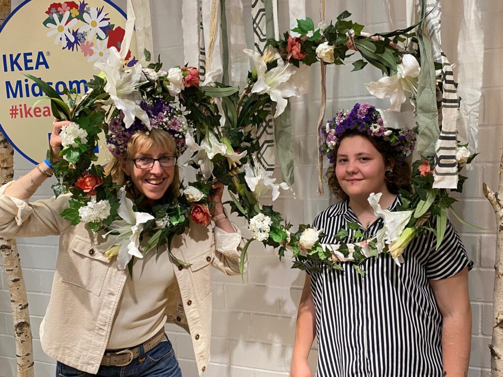 Sylvie und Kathi die ihren Körper für ein Foto durch Blumenkränze halten