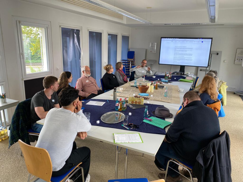 Mehrere Menschen sitzen um einen Tisch. 