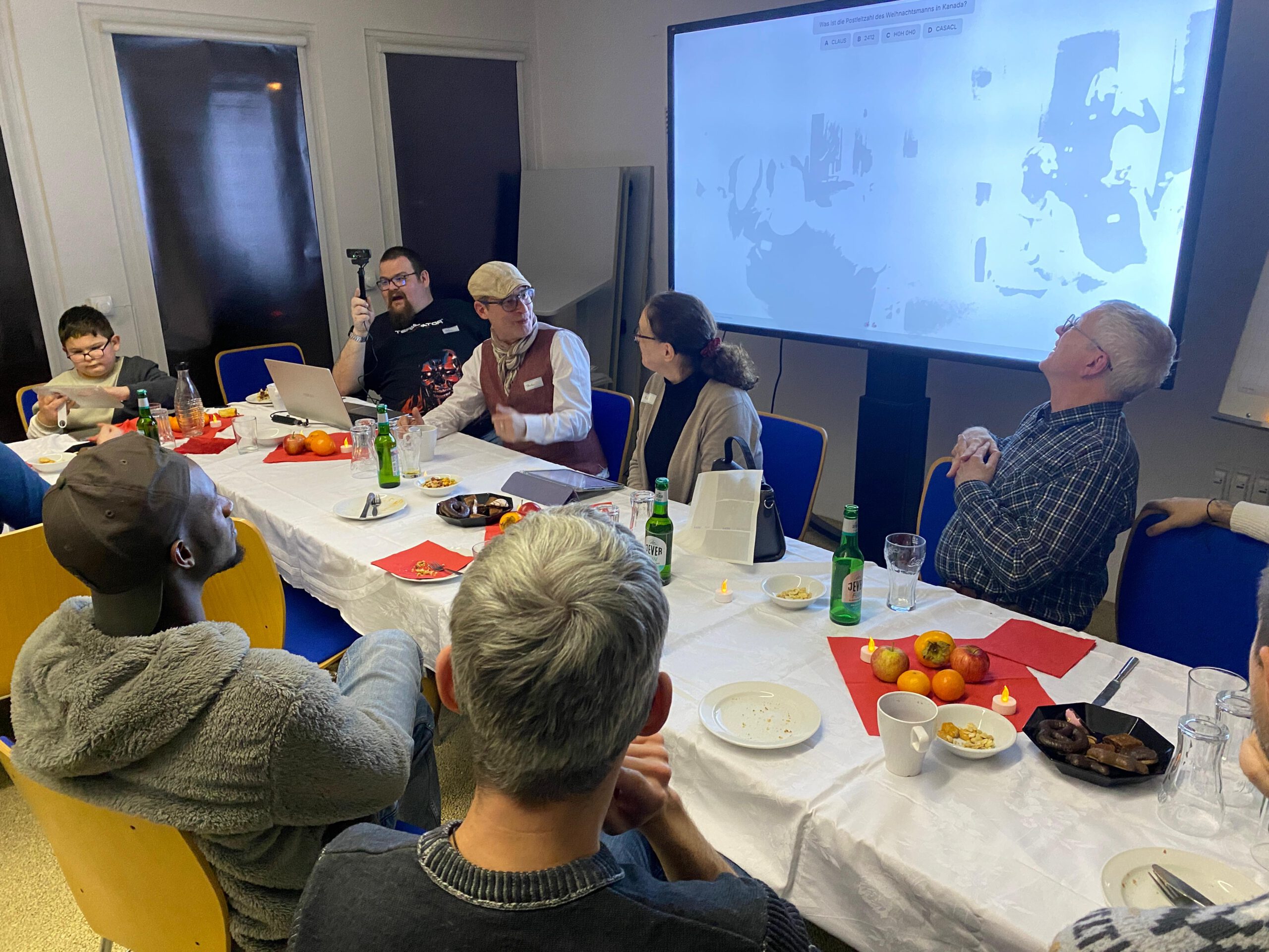 Alle sitzen an einer großen Tafel und unterhalten sich.