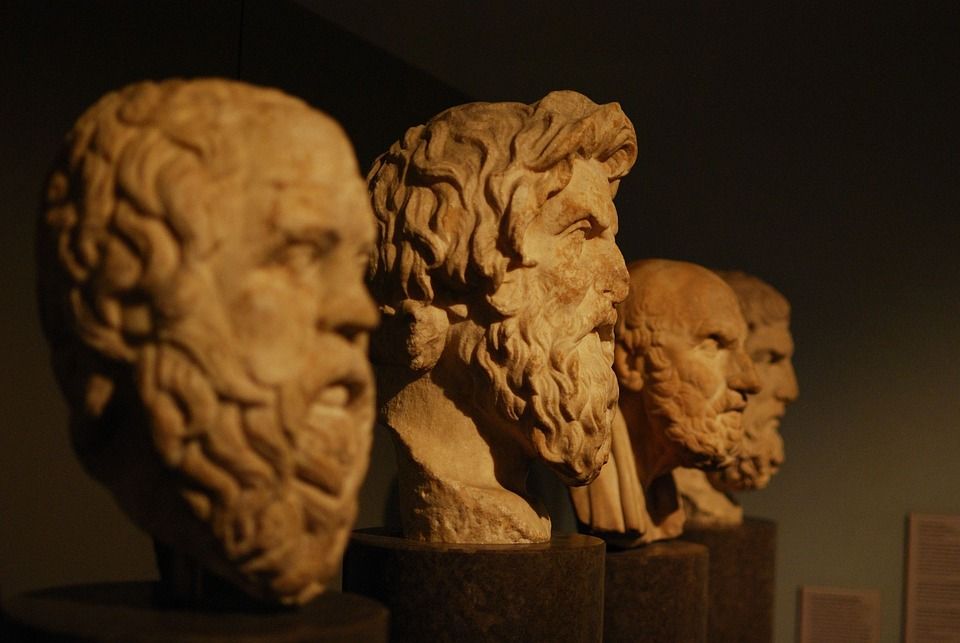 Das Bild zeigt Köpfe von Philosophen im antiken Stil als Steinform.