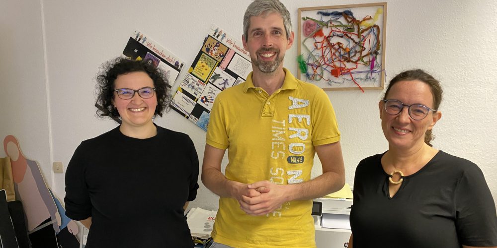 Auf dem Bild ist der neue Vorstand von Menschen in Hanau e.V. zu sehen: links Cettina, rechts Katja und in der Mitte Daniel.