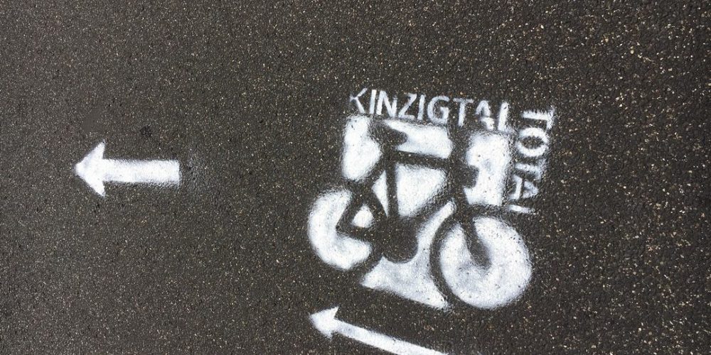 Kinzigtal Total - das Bild zeigt einen in weißer Farbe aufgesprühten Wegweiser auf der Straße