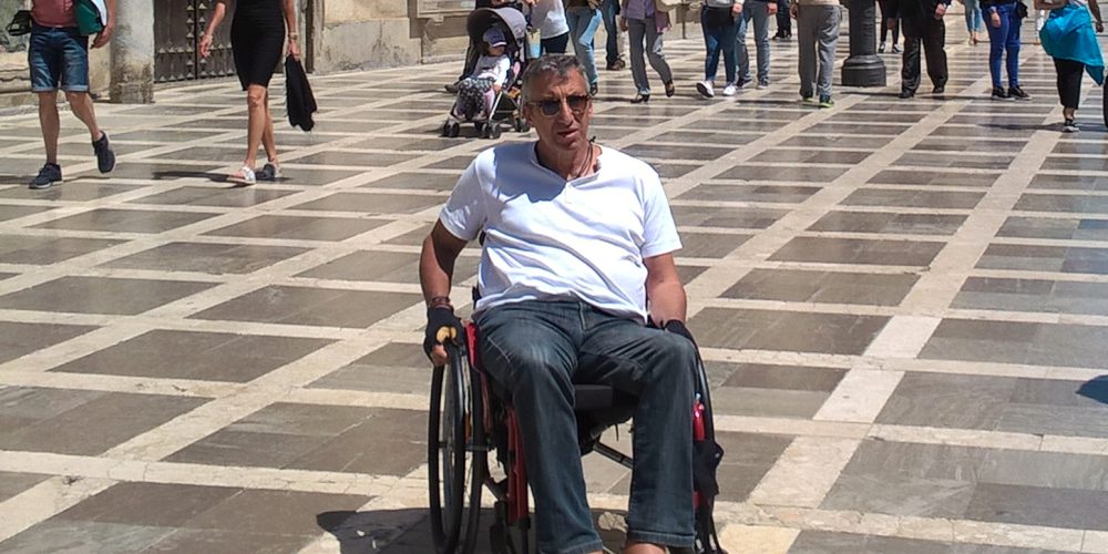 Jürgen im Rollstuhl sitzend im Mittelpunkt des Fotos in einer Einkaufsstraße in Andalusien