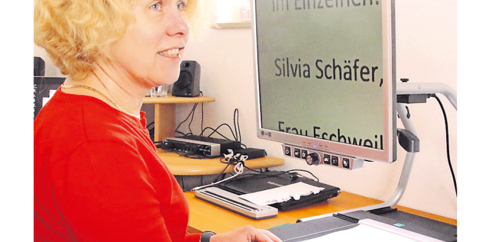 Silvia Schäfer vom TIBS vor ihrem Bildschirm. Man sieht groß geschrieben ihren Namen auf diesem.