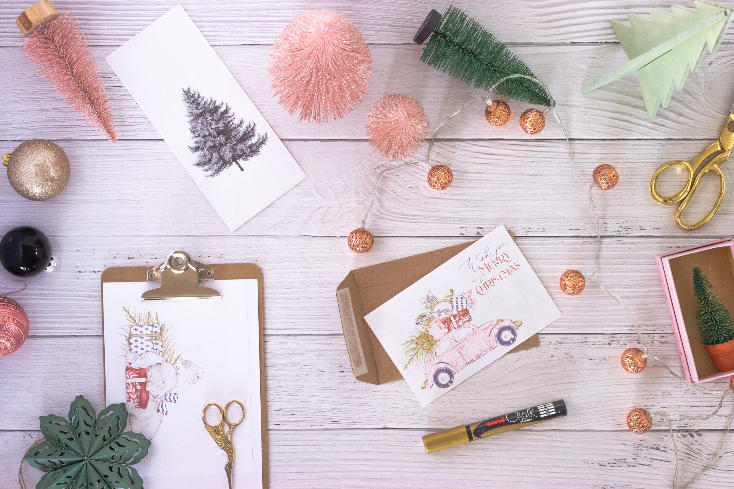 Kreativ-Werk-Stadt: Auf einem Holztisch liegen verschiedene Weihnachtsbastelsachen wie Karten, kleine Tannenbäume, Scheren und Stifte verteilt rum