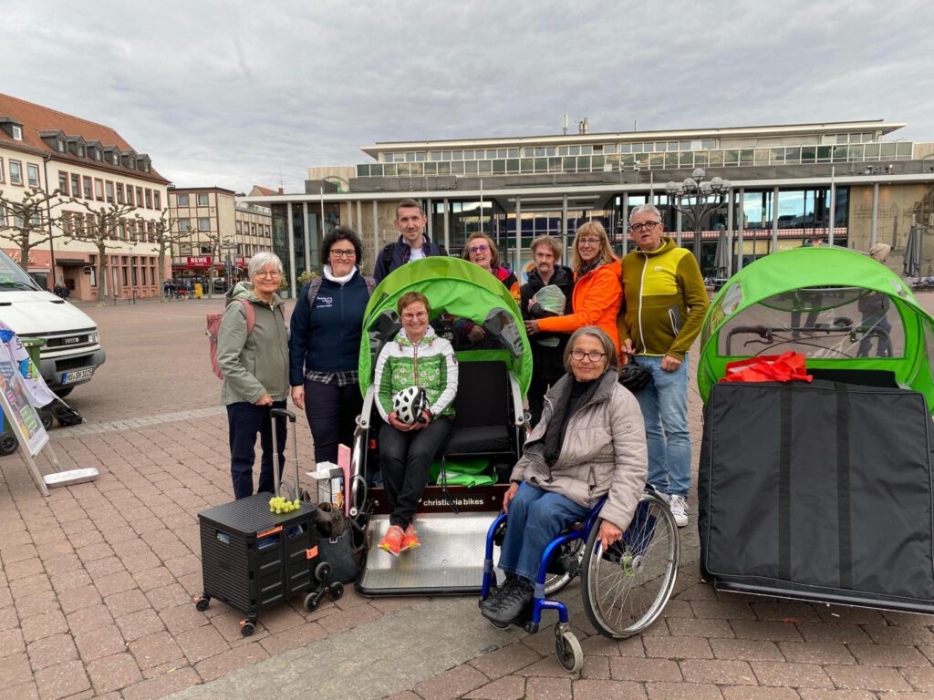 Ein Gruppenfoto mit der RIkscha in der Mitte auf dem Hanauer Markplatz