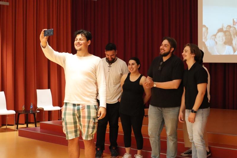 Szene aus dem interaktiven Theaterworkshop. 6 Personen stehen zusammen für ein Selfie.
